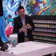 Demoing the game at the Lightseekers event, next to a wall of cards.
